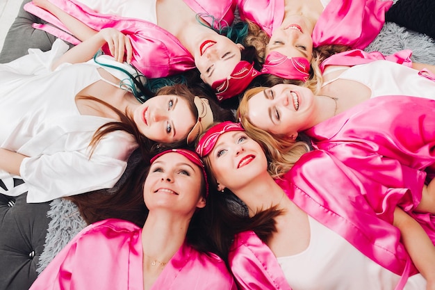 Bridesmaids in pink bathrobes with bride