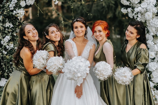 Photo bridesmaids smiling together with the bride the bride and her fun friends celebrate the wedding after the ceremony in matching dresses bride and friends in nature