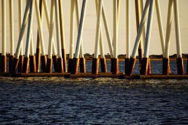 Bridge amidst sea against sky