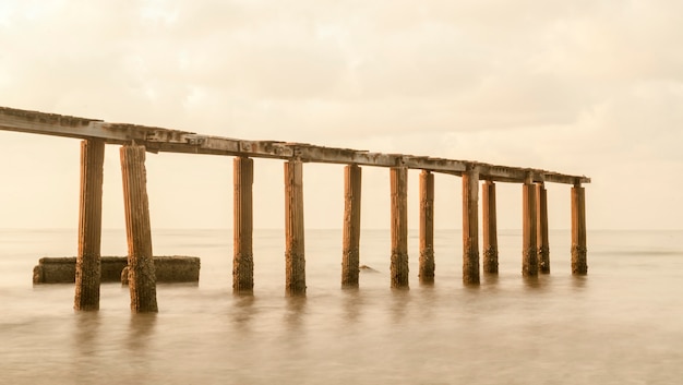 Bridge on beach in sunrise and sea wave in Rayong, Thailand