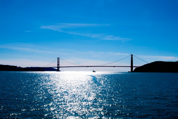 Bridge over calm sea against sky