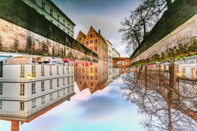 Bridge over canal amidst buildings against sky