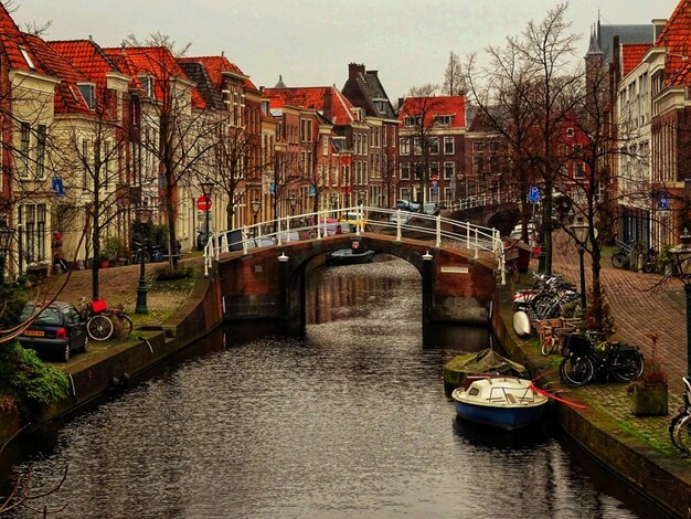 Photo bridge over canal amidst buildings in city