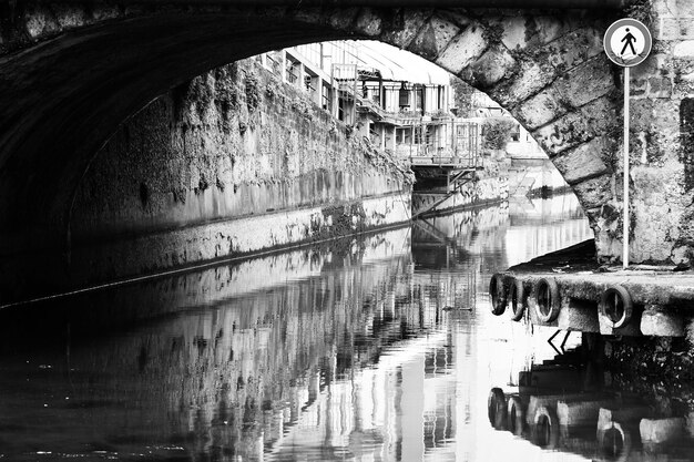 Photo bridge over canal amidst buildings