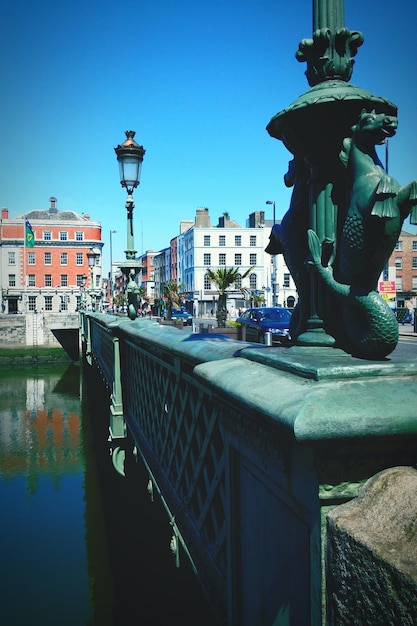 Bridge in city against clear blue sky