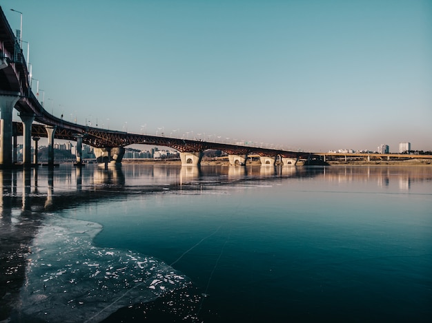 Bridge to city. Drone camera view on river and nature