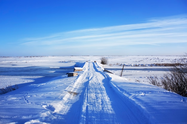 Ponte coperto di neve nel campo invernale