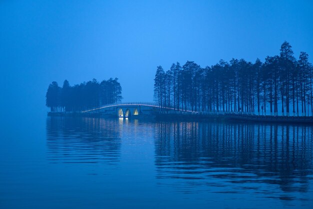 Bridge over lake against blue sky