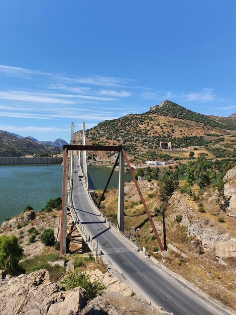 Bridge over mountain against blue sky