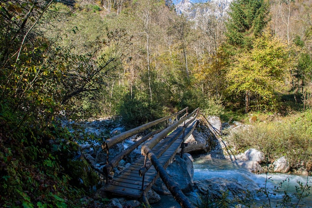 Bridge over the mountain stream in the middle of dolomites mountains in Italy