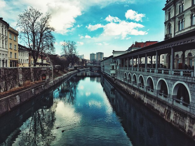 写真 空に照らされた街の建物の中の運河を越えた橋