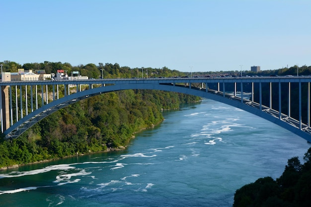 写真 澄んだ青い空に沿って川を渡る橋