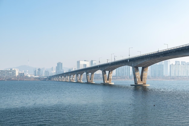 写真 明るい空の前で川を渡る橋