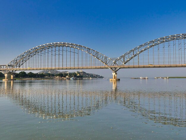 Photo bridge over river against blue sky