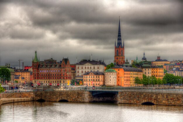 Photo bridge over river against buildings in city