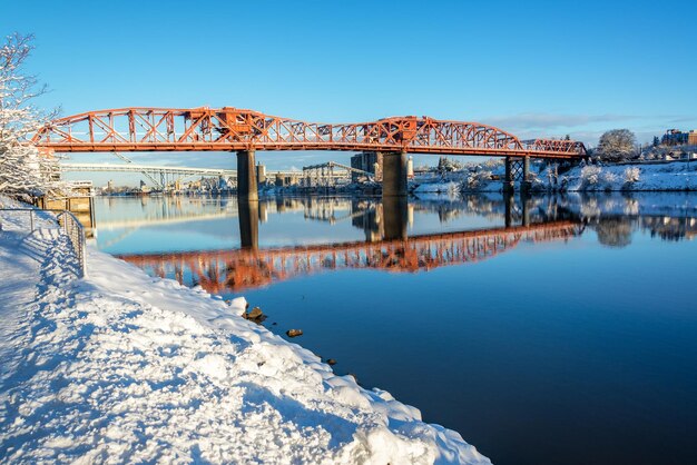 Foto ponte sul fiume contro un cielo blu limpido durante l'inverno