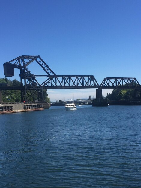 Bridge over river against clear blue sky