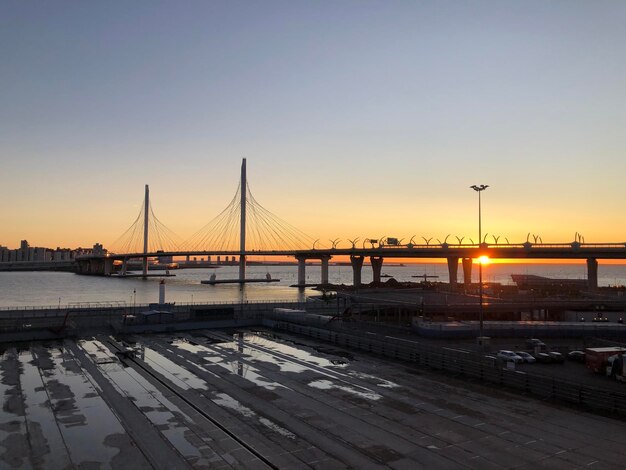 Bridge over river against clear sky during sunset