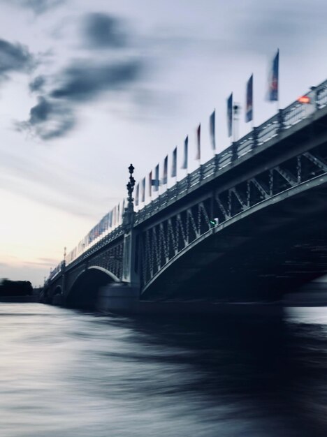 Bridge over river against cloudy sky