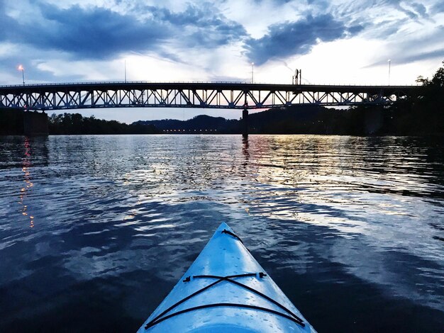 Bridge over river against cloudy sky