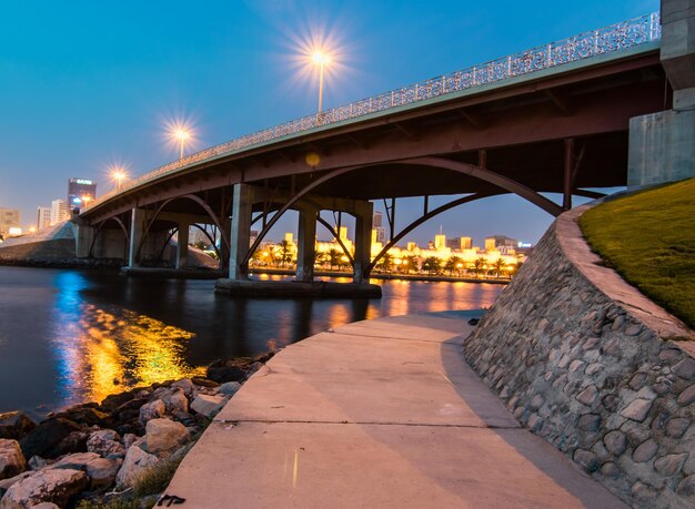 Photo bridge over river against sky in city at night