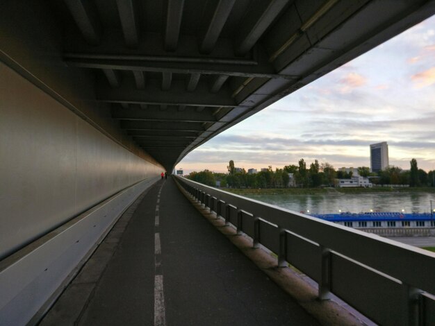 Photo bridge over river against sky in city