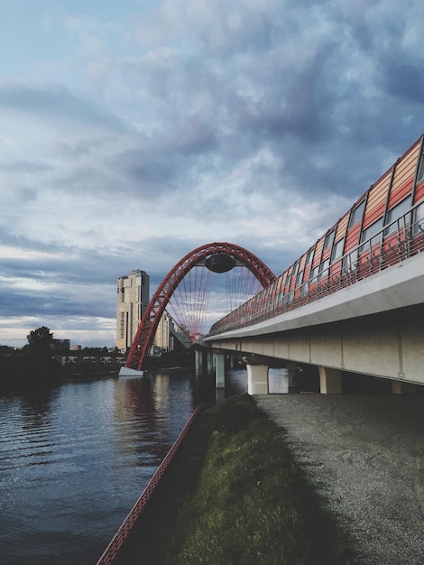 Bridge over river against sky in city