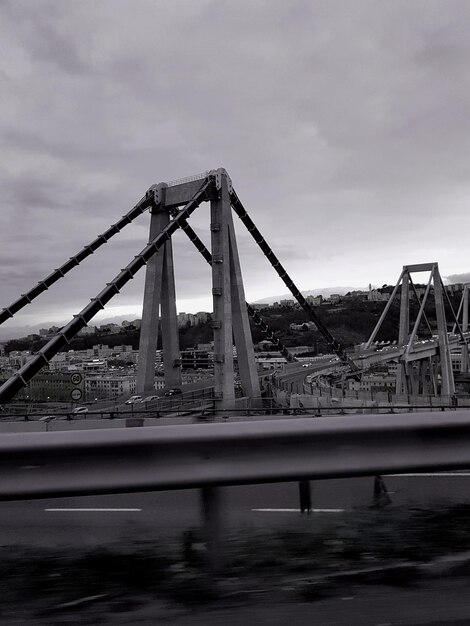 Bridge over river against sky in city