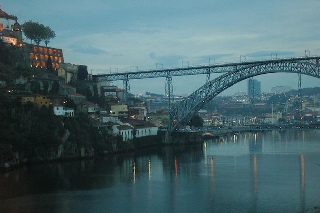 Bridge over river against sky in city