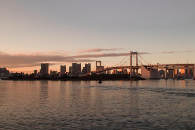 夕暮れの空に映る川を越えた橋