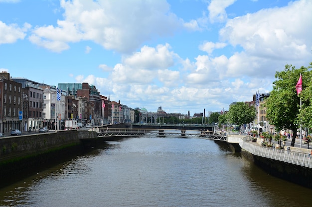 Bridge over river amidst buildings in city against sky