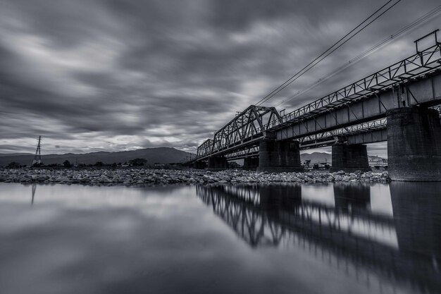 A bridge over the river in black and white