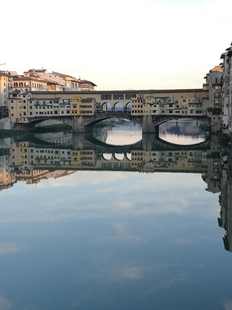 Foto ponte sul fiume da edifici contro il cielo in città