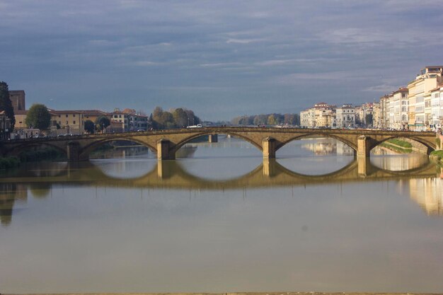 Мост через реку с зданиями напротив неба в городе