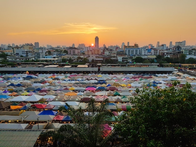 夕暮れの空に照らされた街の建物に沿って川を渡る橋