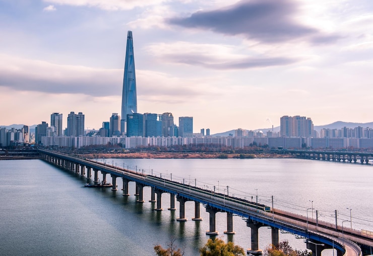 Photo 空に照らされた街の建物に沿って川を渡る橋
