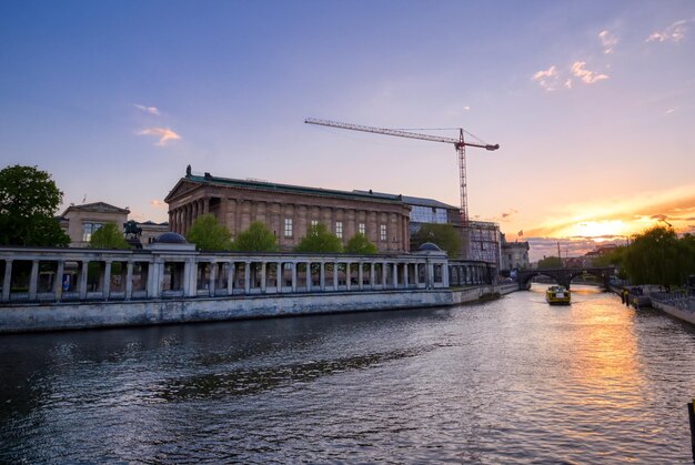 Bridge over river by buildings in city against sky