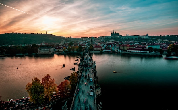 Photo bridge over river in city against sky during sunset