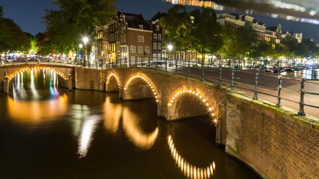 Photo bridge over river in city at night