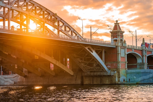 Мост через реку в лучах заката в Москве