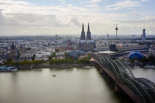 Photo bridge over river with buildings in background