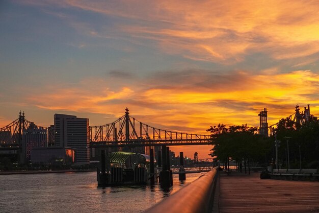 夕暮れの街を背景にした川を越えた橋