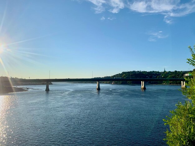 Bridge over sea against blue sky