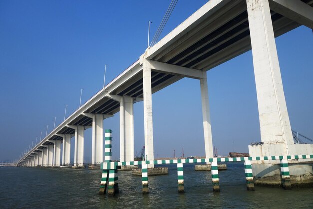 澄んだ青い空に沿って海を越える橋