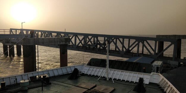 Bridge over sea against clear sky during sunset