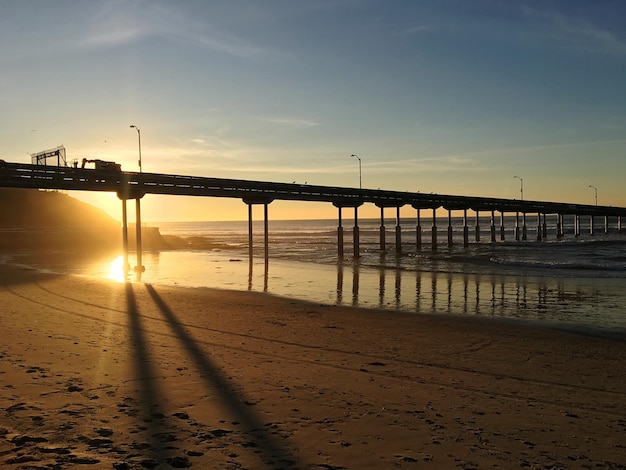 Bridge over sea against sky during sunset