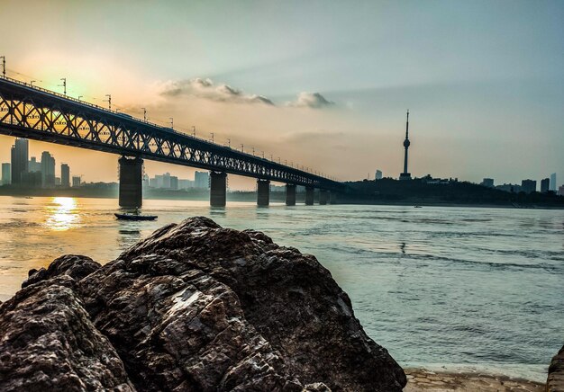 Bridge over sea against sky during sunset