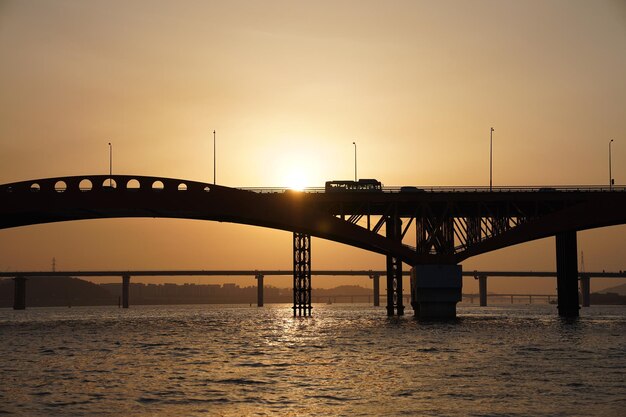 夕暮れの空と対照的に海を越えた橋