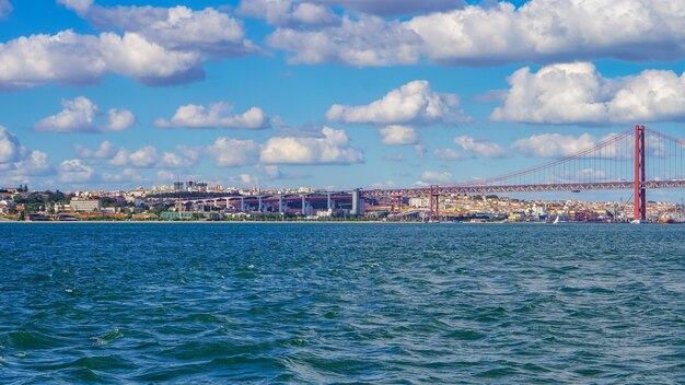 Bridge over sea by city against sky