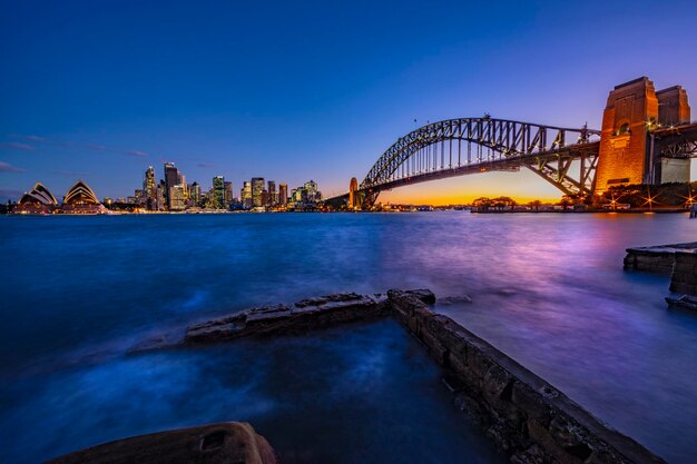 Foto ponte sul mare in città al crepuscolo